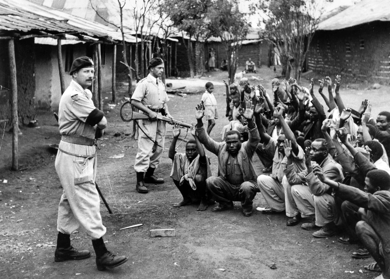 British Soldiers keep guard on detainees in 1954.